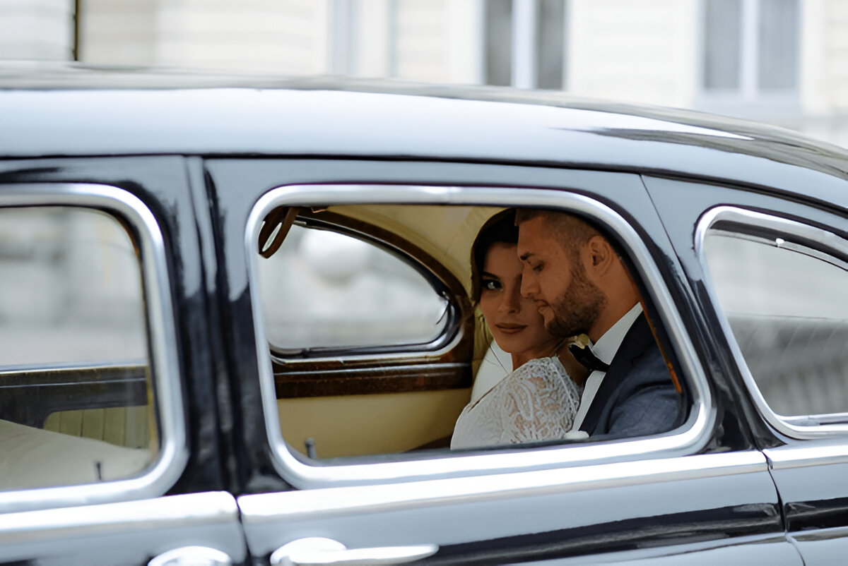 Gelin ve damat klasik arabada mutlu anlarını paylaşıyor.