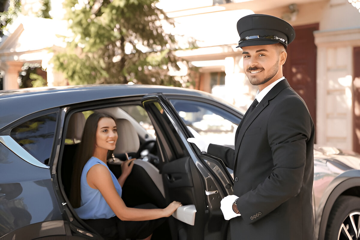 VIP şoför, lüks araç kapısını açarken kadın yolcu araca biniyor.