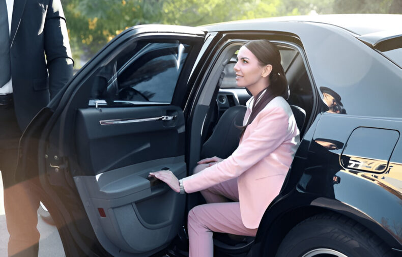 Pembe takım elbiseli kadın VIP araca binerken yanında duran şoför