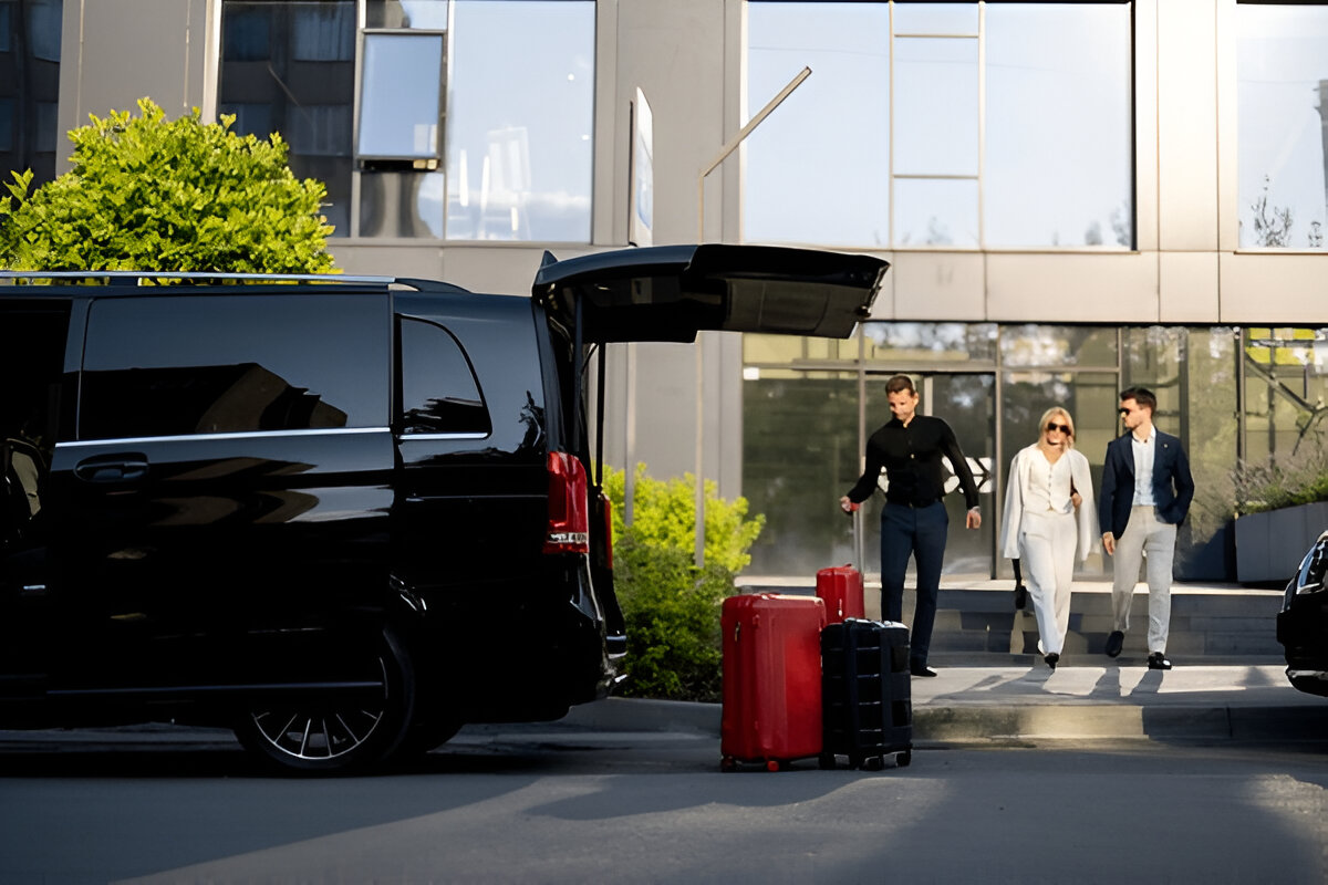 VIP minibüsün bagajına valizler yerleştirilirken iş insanları araca doğru yürüyor