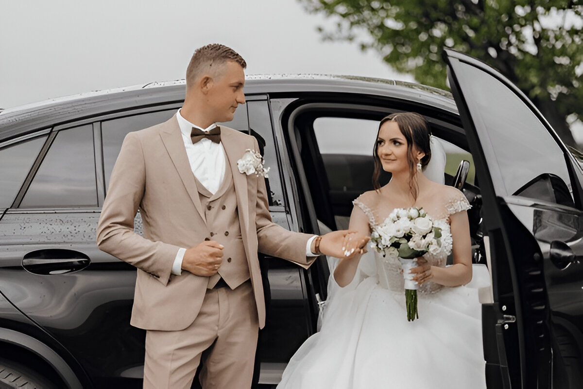 Damat, arabadan inen gelinine nazikçe elini uzatıyor.
