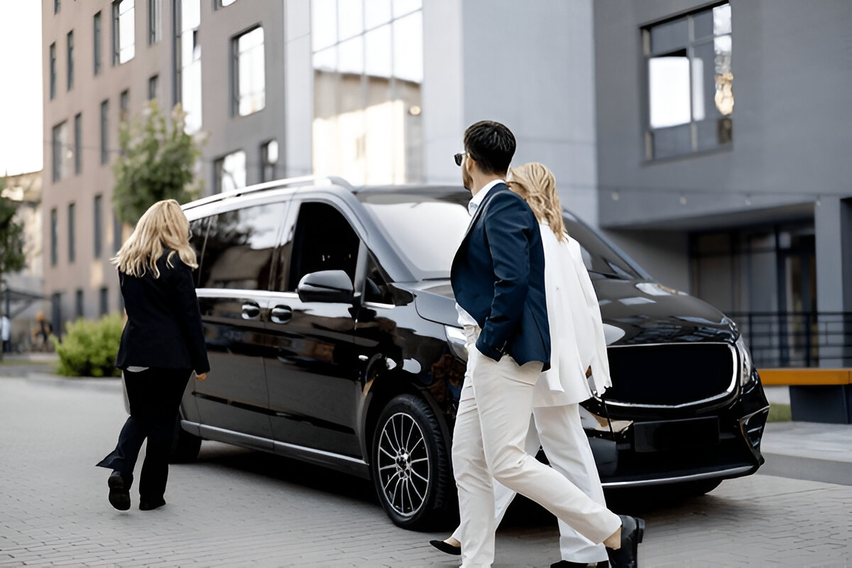 Siyah VIP minibüsün önünde yürüyen iş insanları.